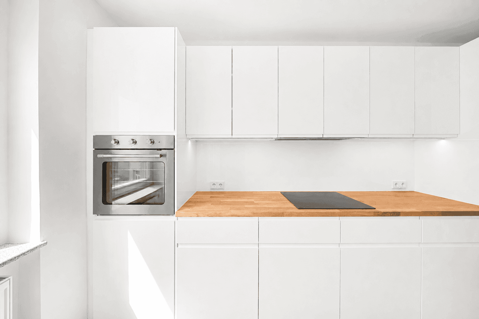 Detailansicht der modernen Küche mit integriertem Backofen und Induktionskochfeld.
