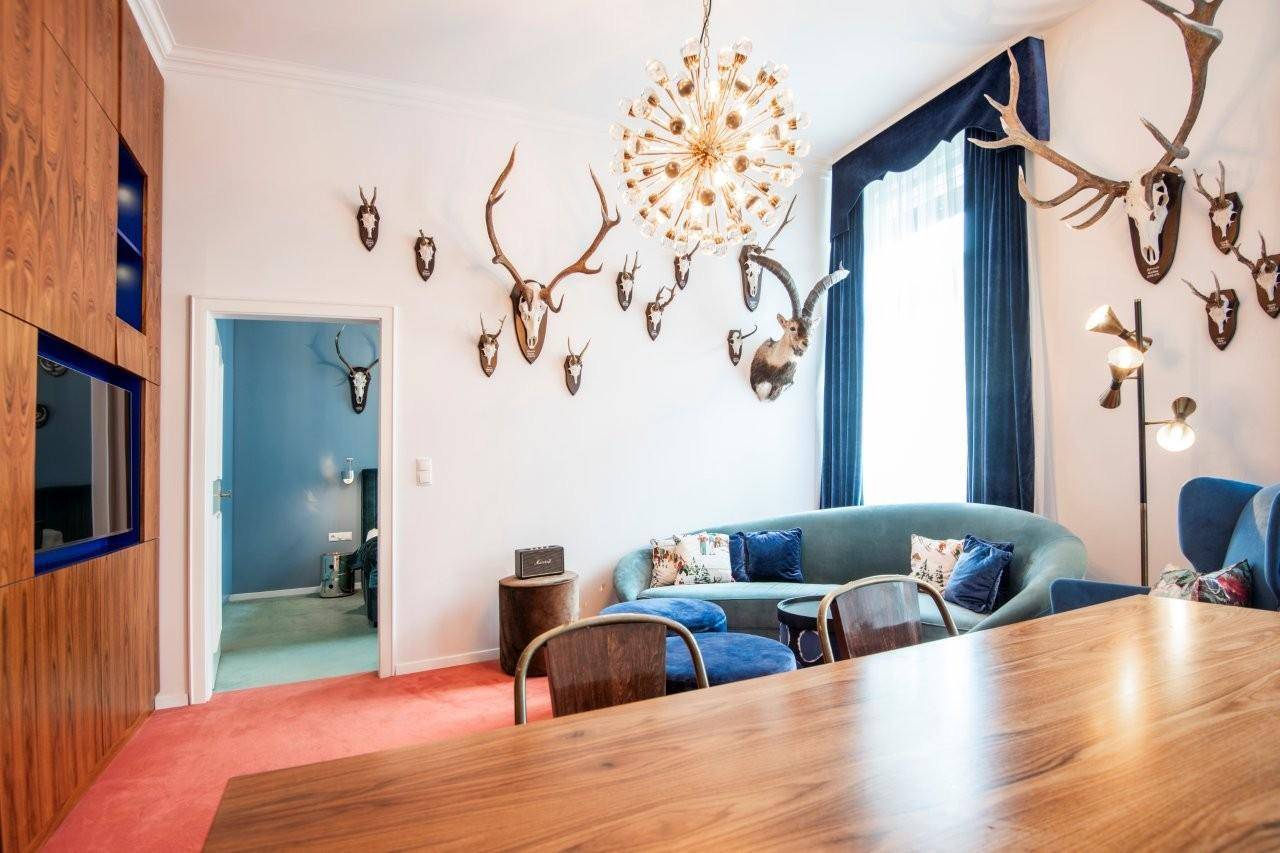 Opulenter Wohn- und Essbereich mit Hirschgeweih-Dekoration und luxuriöser Beleuchtung.