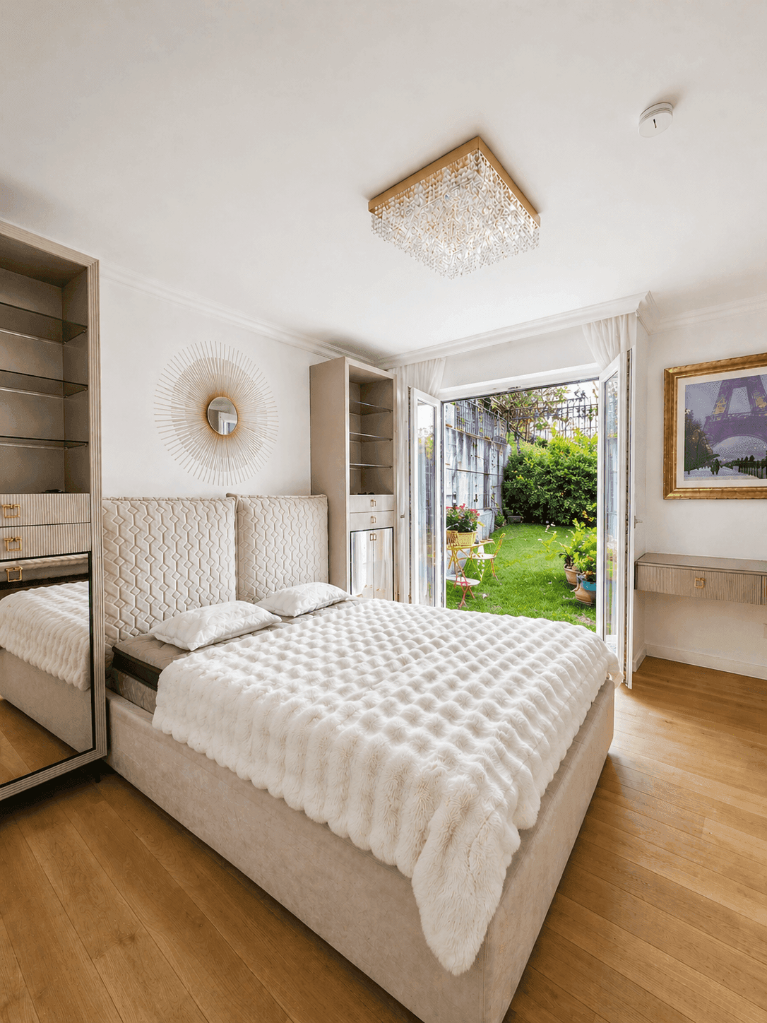 Gemütliches Schlafzimmer mit stilvollem Kopfteil, Holzboden und Blick ins Grüne.