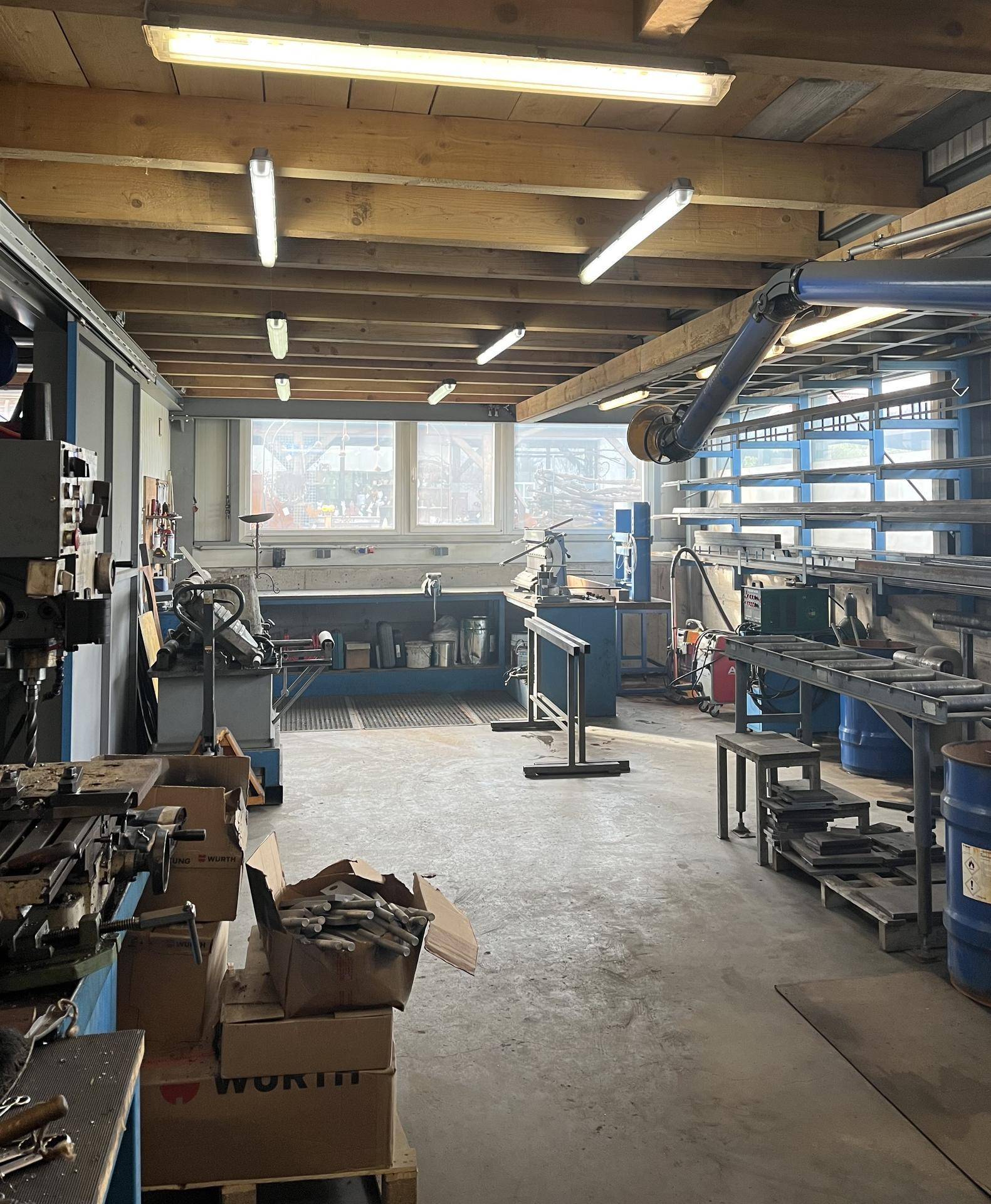 Werkstattraum mit verschiedenen Maschinen, Werkbänken und Werkzeugen, bereit für handwerkliche Arbeiten.
