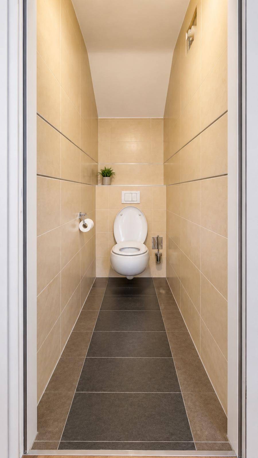 Kleines Gäste-WC mit wandhängender Toilette und modernen Fliesen.