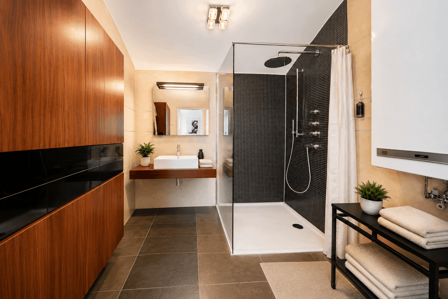 Modernes Badezimmer mit begehbarer Dusche, Holzschränken und eleganten Fliesen.