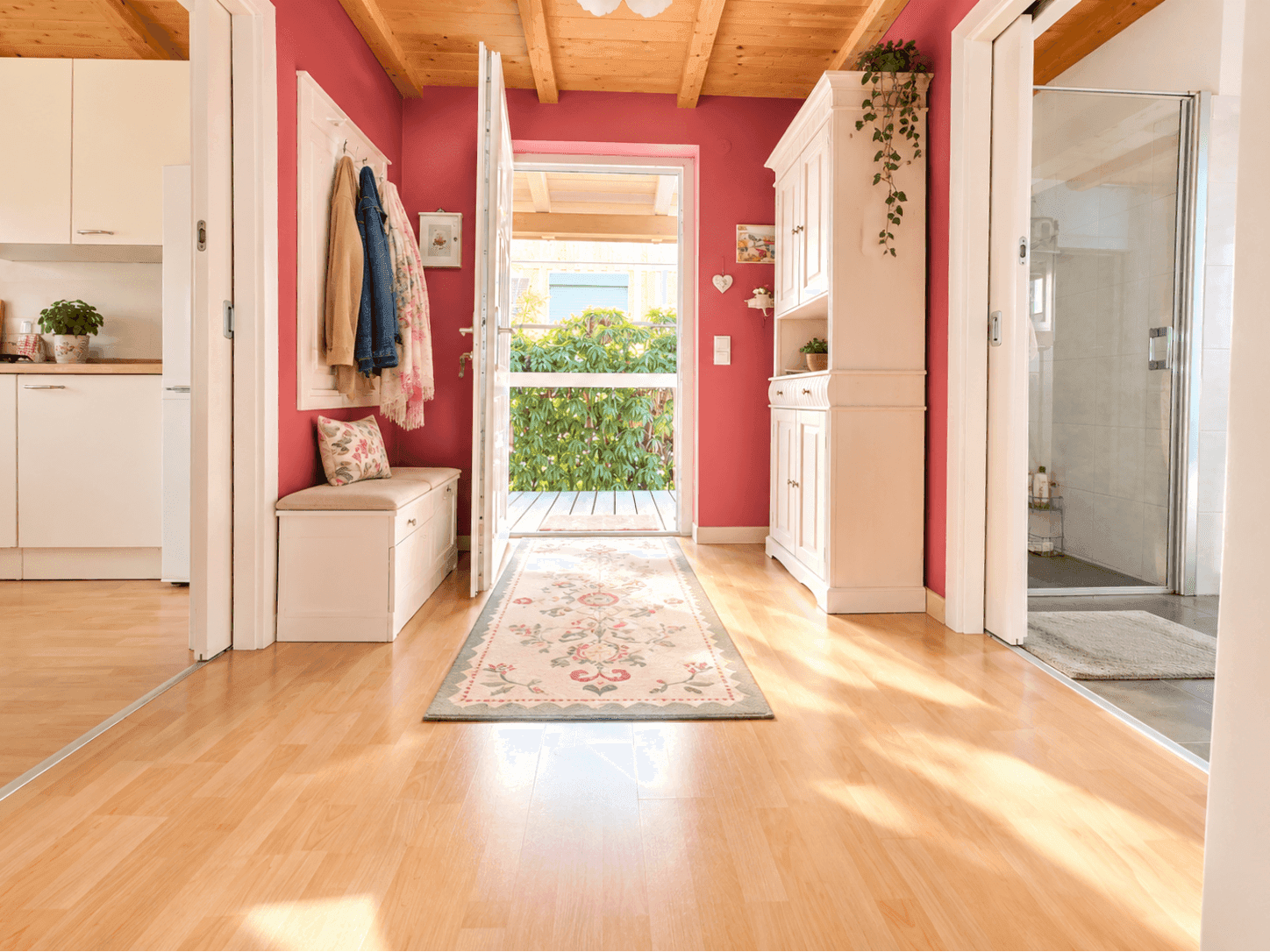 Heller Eingangsbereich mit Garderobe, Holzboden und Blick in den Garten.