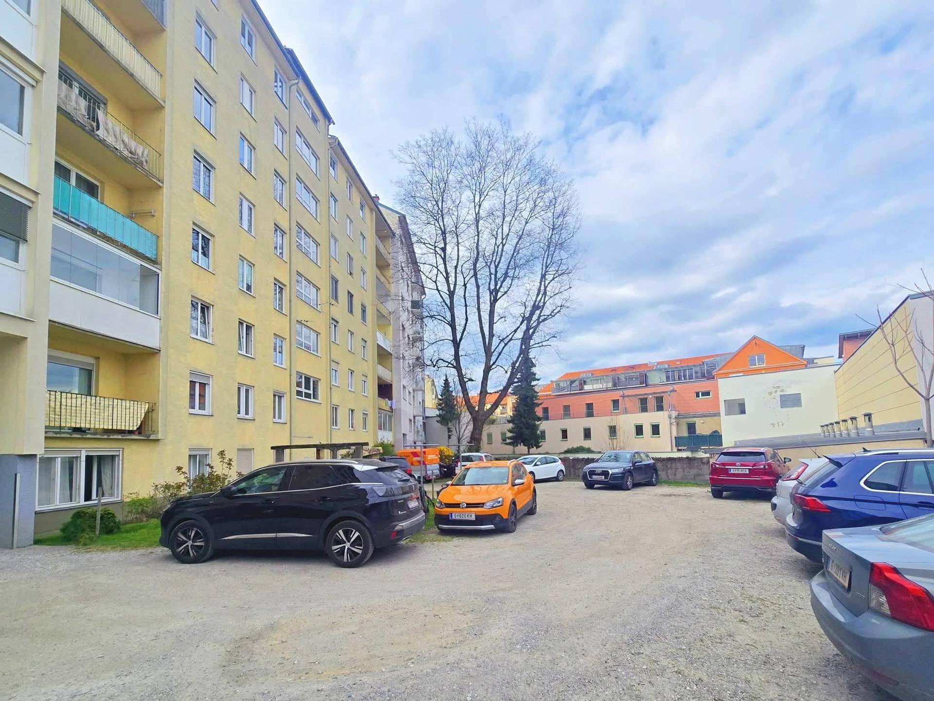 Außenansicht des Wohngebäudes mit Parkplätzen im Freien.