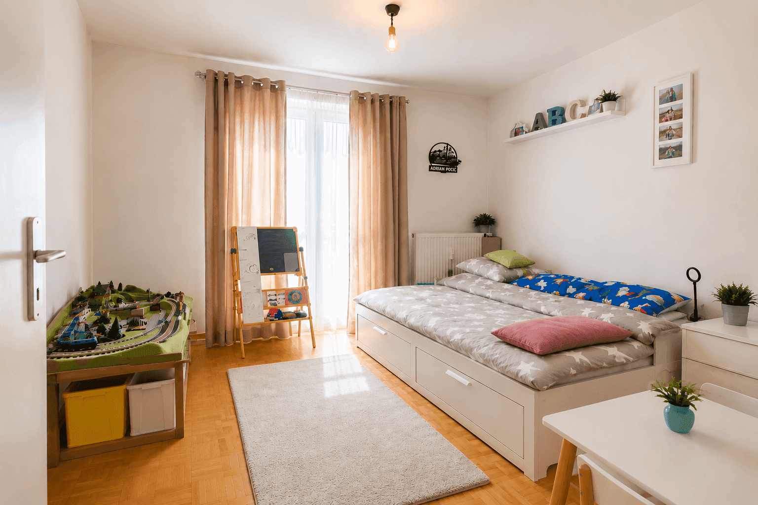 Kinderzimmer mit Holzboden, Bett, Spielbereich und viel Tageslicht durch das Fenster.