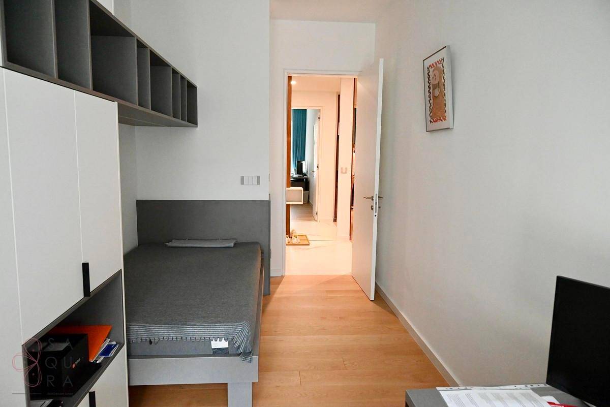 Kinder- oder Gästezimmer mit Einzelbett, Einbauschränken und Blick auf den Flur.