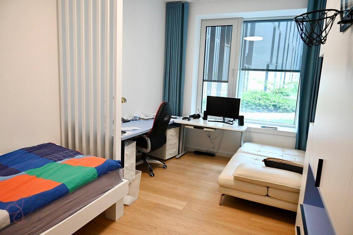 Jugendzimmer mit Bett, Schreibtisch und Sofa, ausgestattet mit einem Basketballkorb an der Wand.