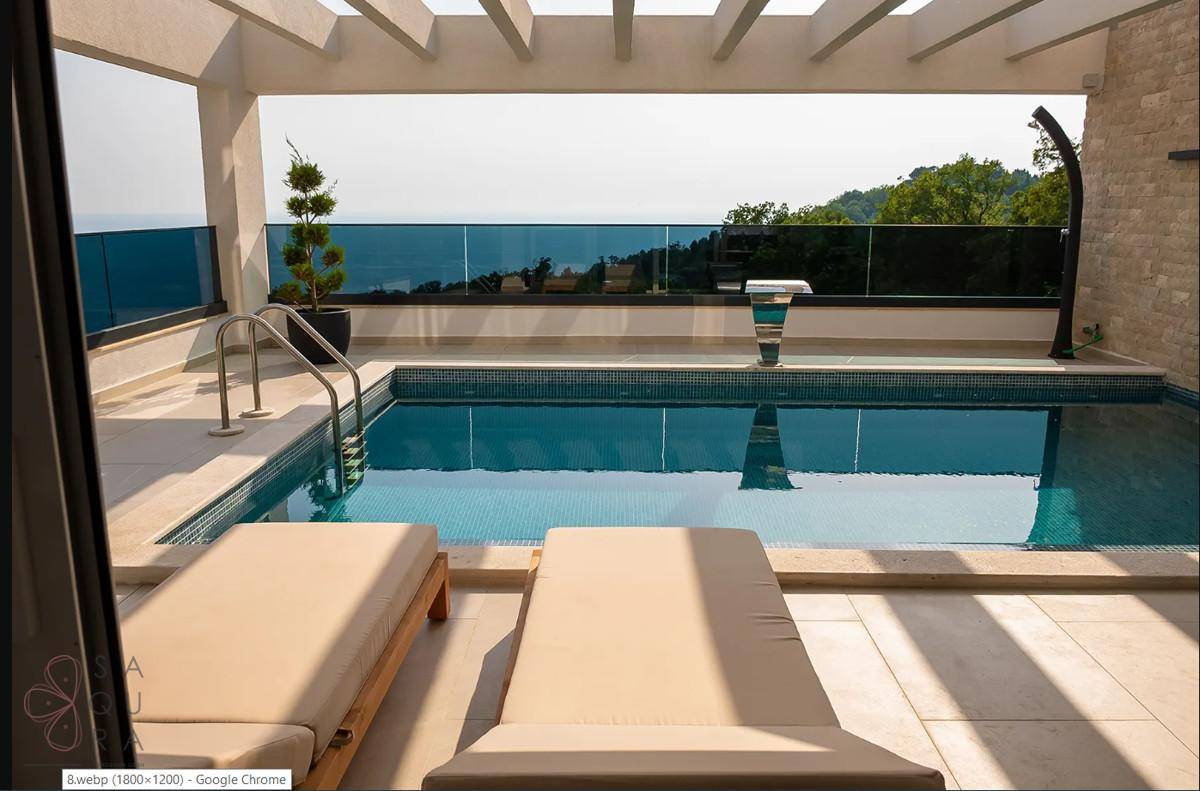 Sonniger Terrassenbereich mit privatem Pool, Liegestühlen und weitem Blick auf das Meer und die Landschaft.