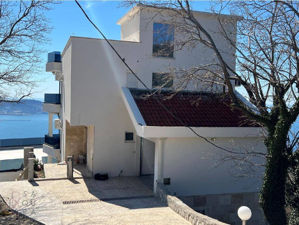 Rückansicht der Villa mit Zufahrt und einem weiten Blick auf das Meer und die Küste.
