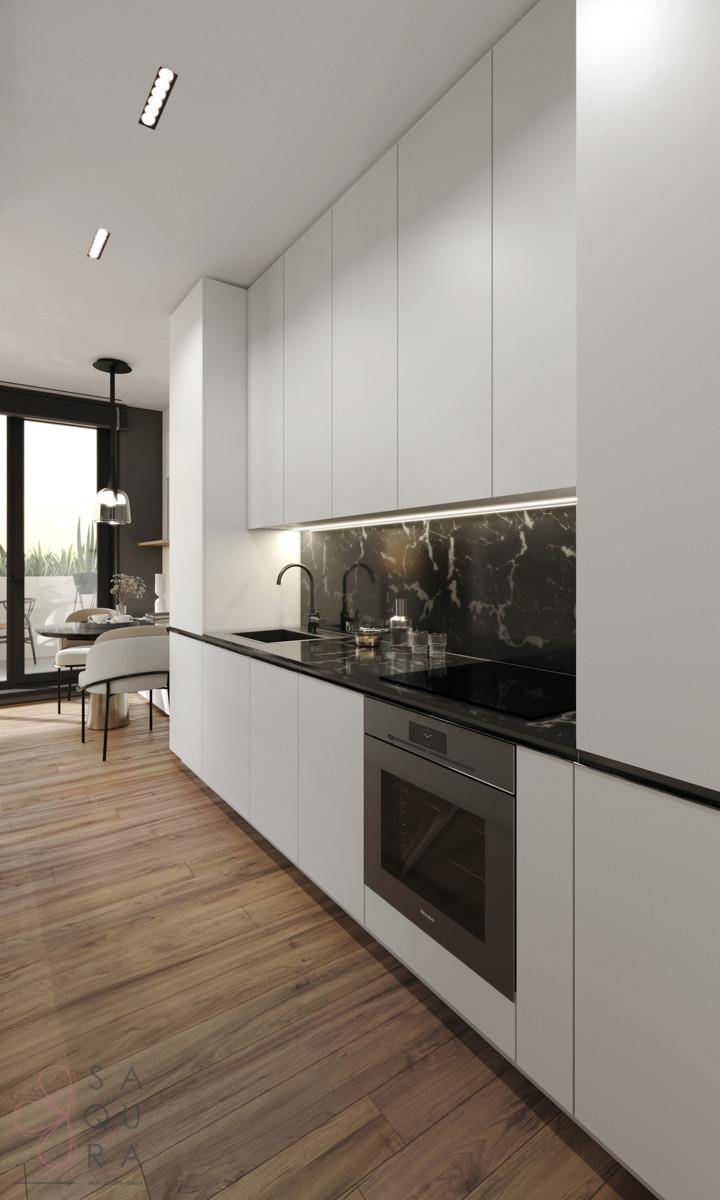 Moderne weiße Küche mit integrierten Geräten, dunkler Arbeitsplatte und Marmor-Rückwand.