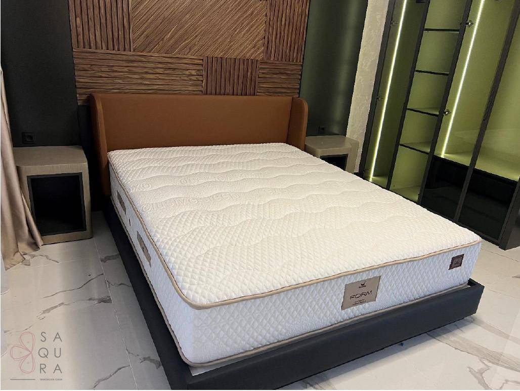 Detailansicht des Bettes mit gepolstertem Kopfteil und der stilvollen Holzwandverkleidung im Schlafzimmer.