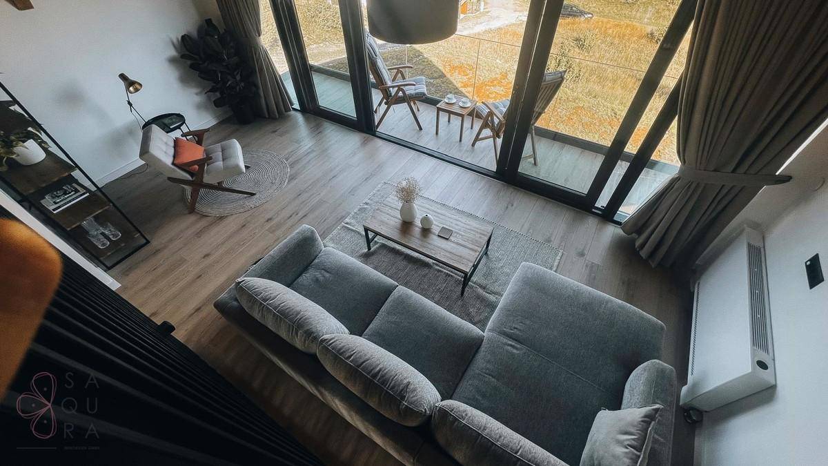 Offener Wohnbereich von oben gesehen mit moderner Einrichtung und Blick auf den Balkon.