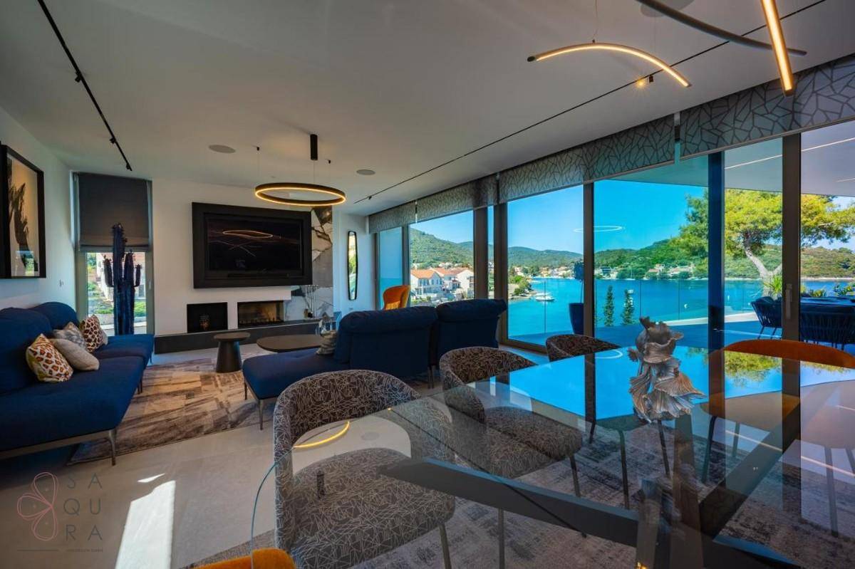 Offener Wohn- und Essbereich mit Meerblick, elegantem Glastisch und bequemen Sofas.