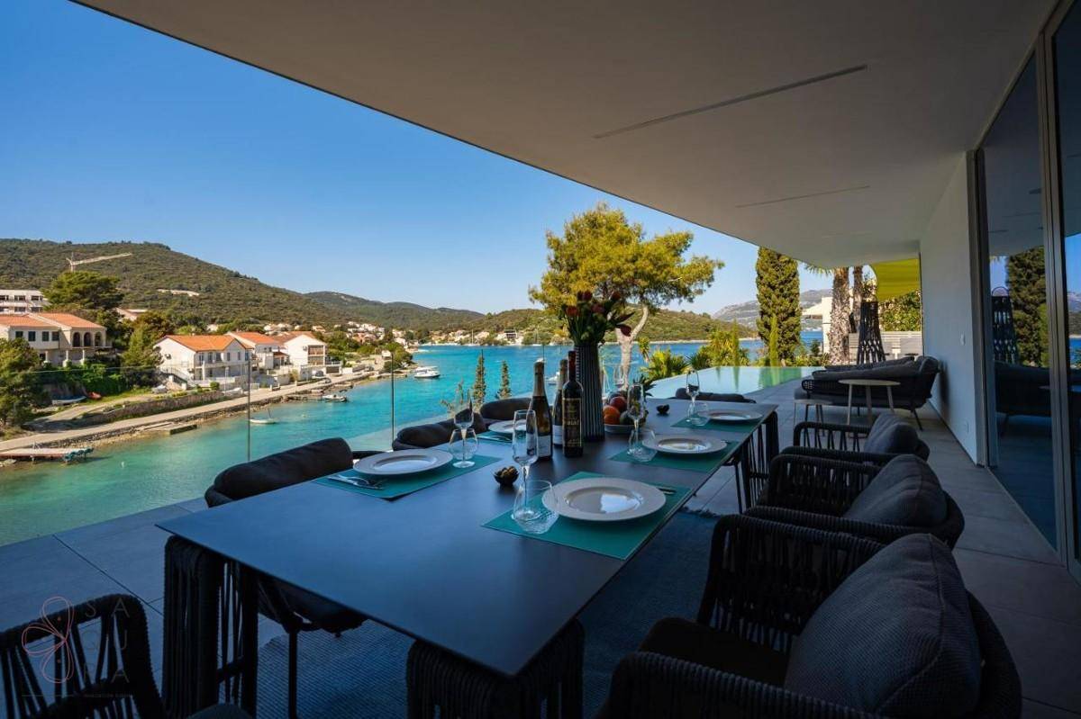 Große Terrasse mit Esstisch und atemberaubendem Blick auf das Meer und die Küstenlandschaft.