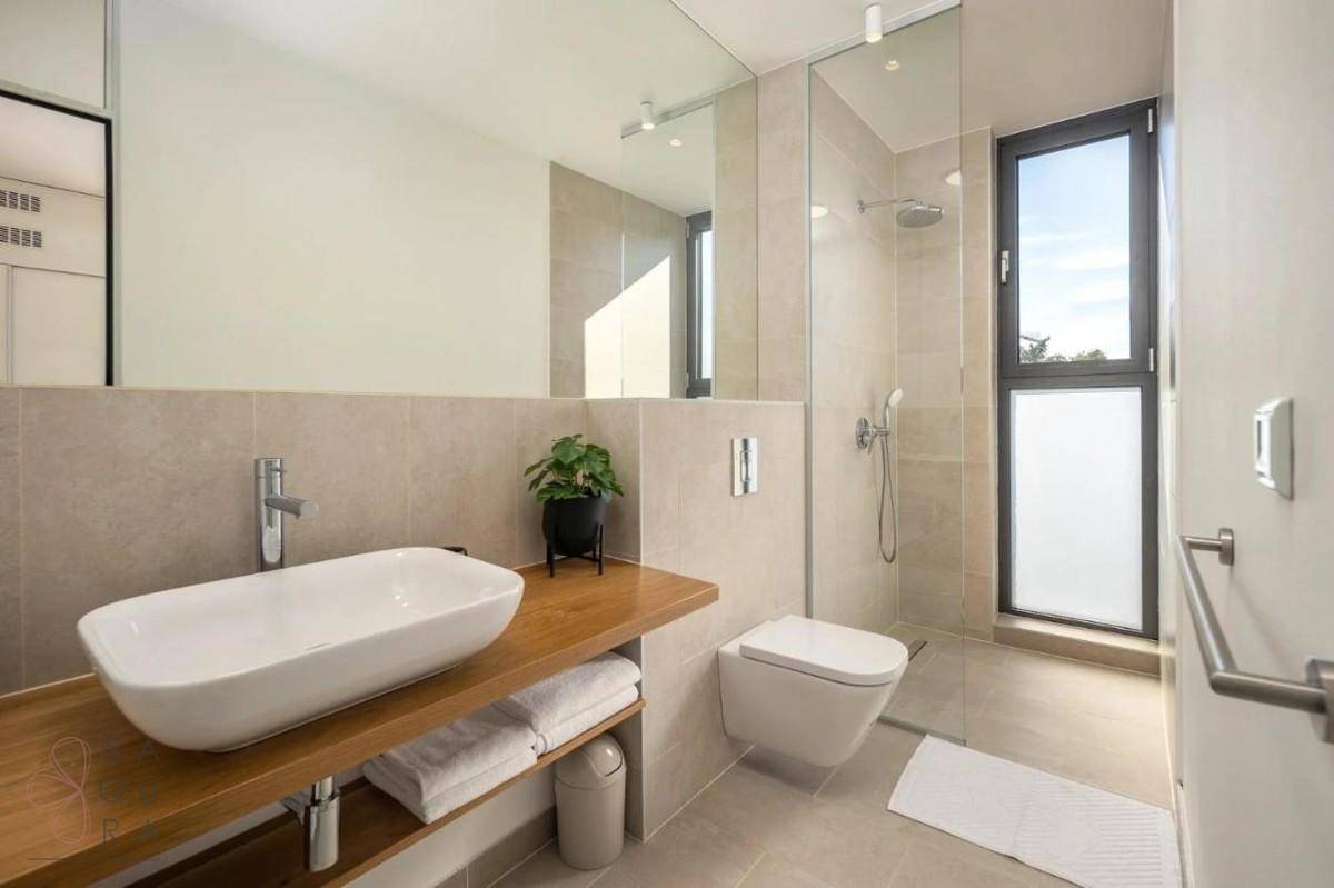 Modernes Badezimmer mit begehbarer Dusche, Einzelwaschbecken und Fenster für Tageslicht.