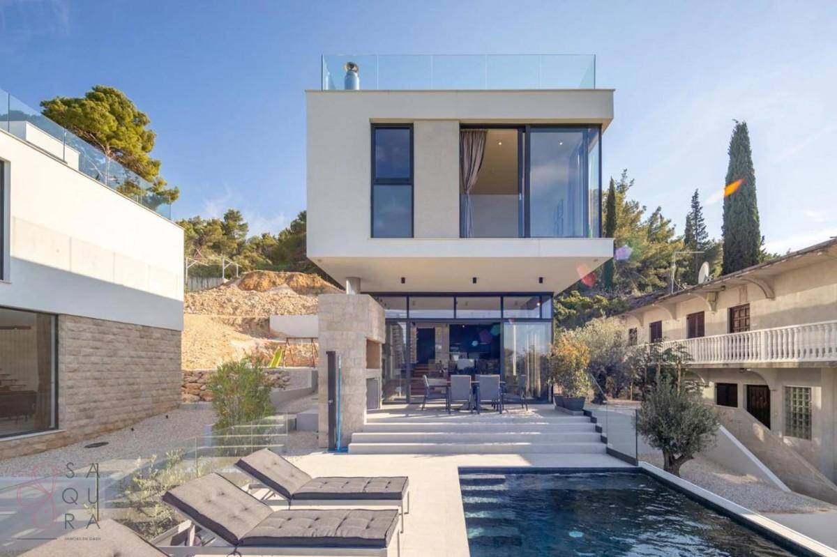 Moderne Villa mit Infinity-Pool, Außentreppe und Essbereich im Freien mit Meerblick.