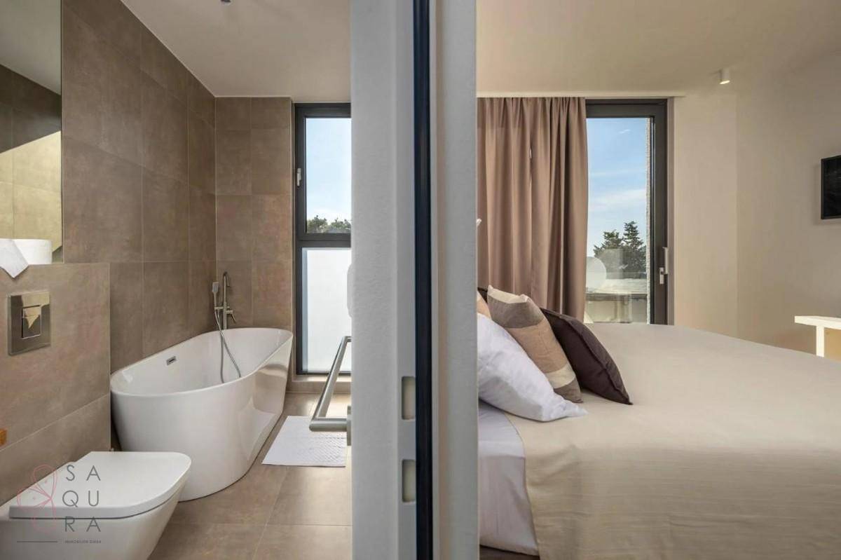 Ensuite-Badezimmer mit freistehender Badewanne und Blick auf die Natur, direkt vom Schlafzimmer zugänglich.