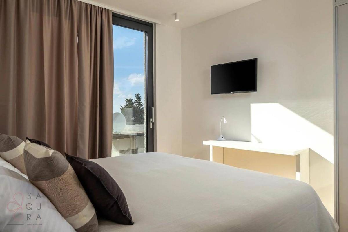 Gemütliches Schlafzimmer mit Doppelbett, Schreibtisch und Fenster mit Blick auf die Umgebung.