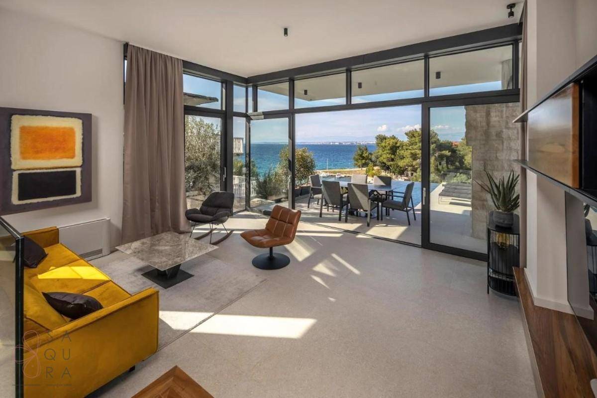 Lichtdurchflutetes Wohnzimmer mit modernem Sofa, Meerblick und direktem Zugang zur Terrasse.