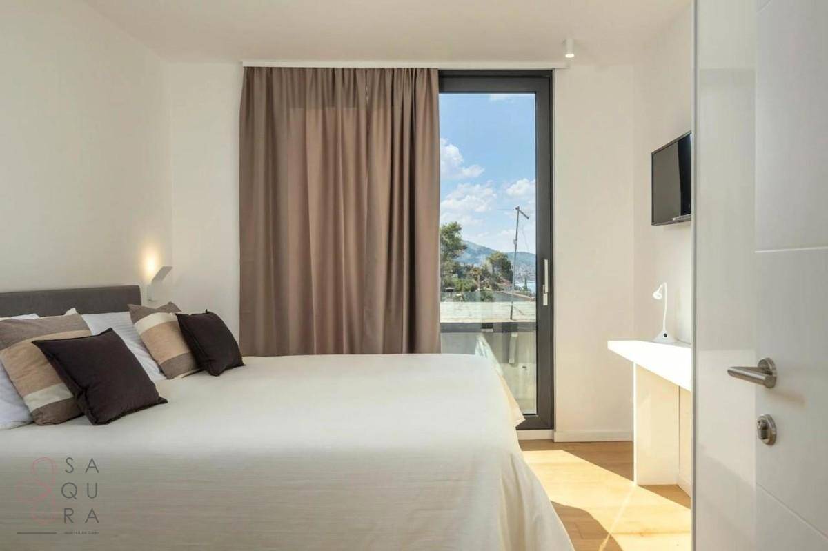 Komfortables Schlafzimmer mit Doppelbett und Zugang zu einem Balkon mit Ausblick.