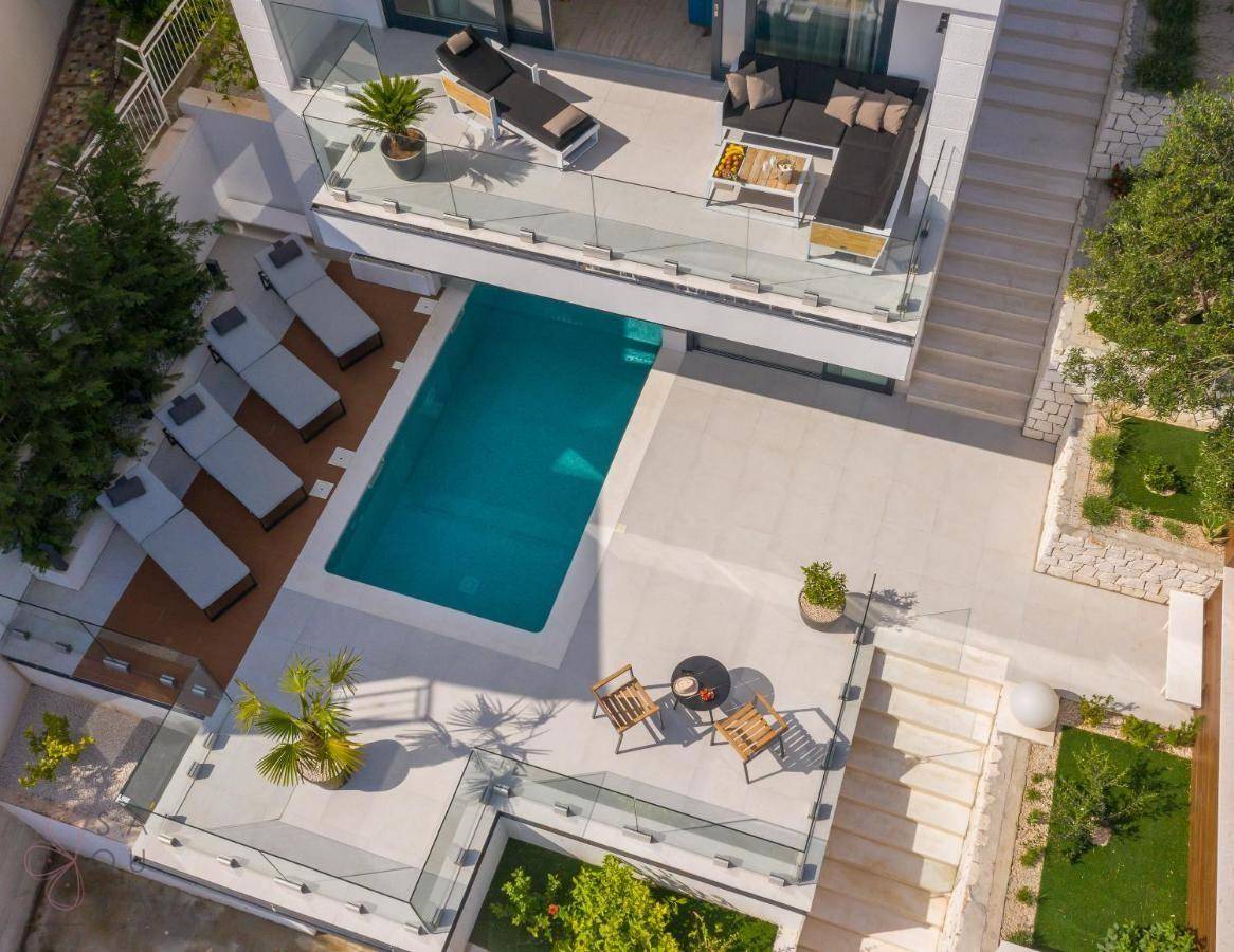 Luftaufnahme der modernen Villa mit mehreren Terrassen, Pool und luxuriösen Außenbereichen.