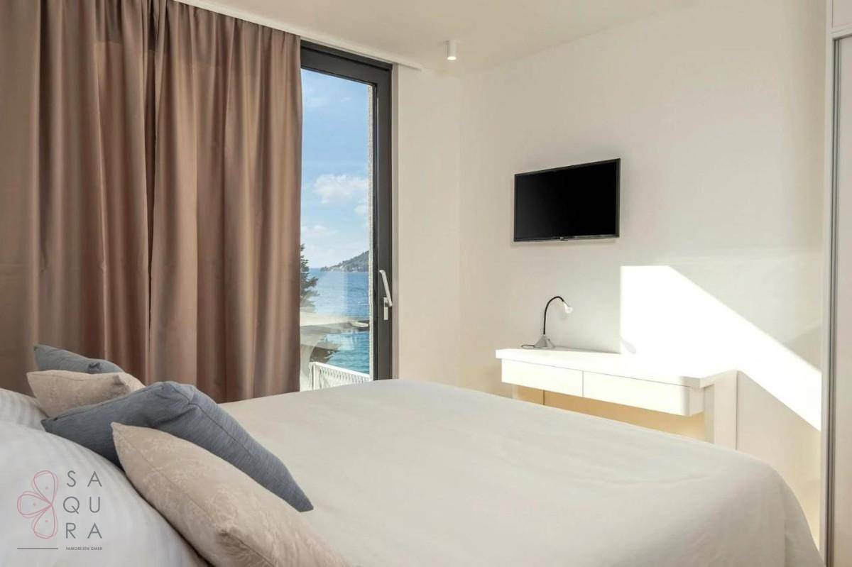 Helles Schlafzimmer mit Doppelbett, Schreibtisch und Fenster mit Blick auf die Umgebung.