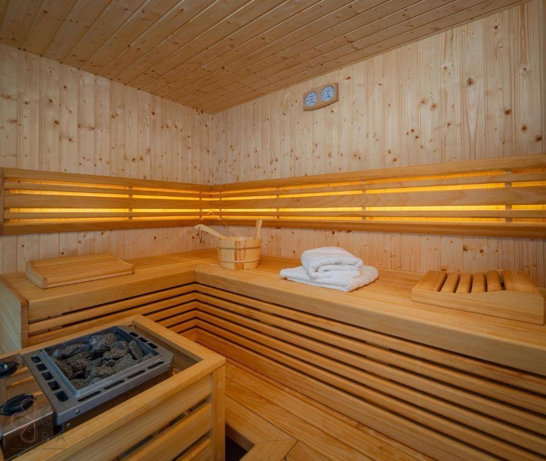 Gemütliche Holzsauna mit traditionellem Ofen, Bänken und indirekter Beleuchtung für pure Entspannung.
