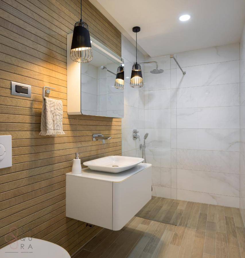 Modernes Badezimmer mit Holzverkleidung, begehbarer Dusche und stilvollem Waschbecken.