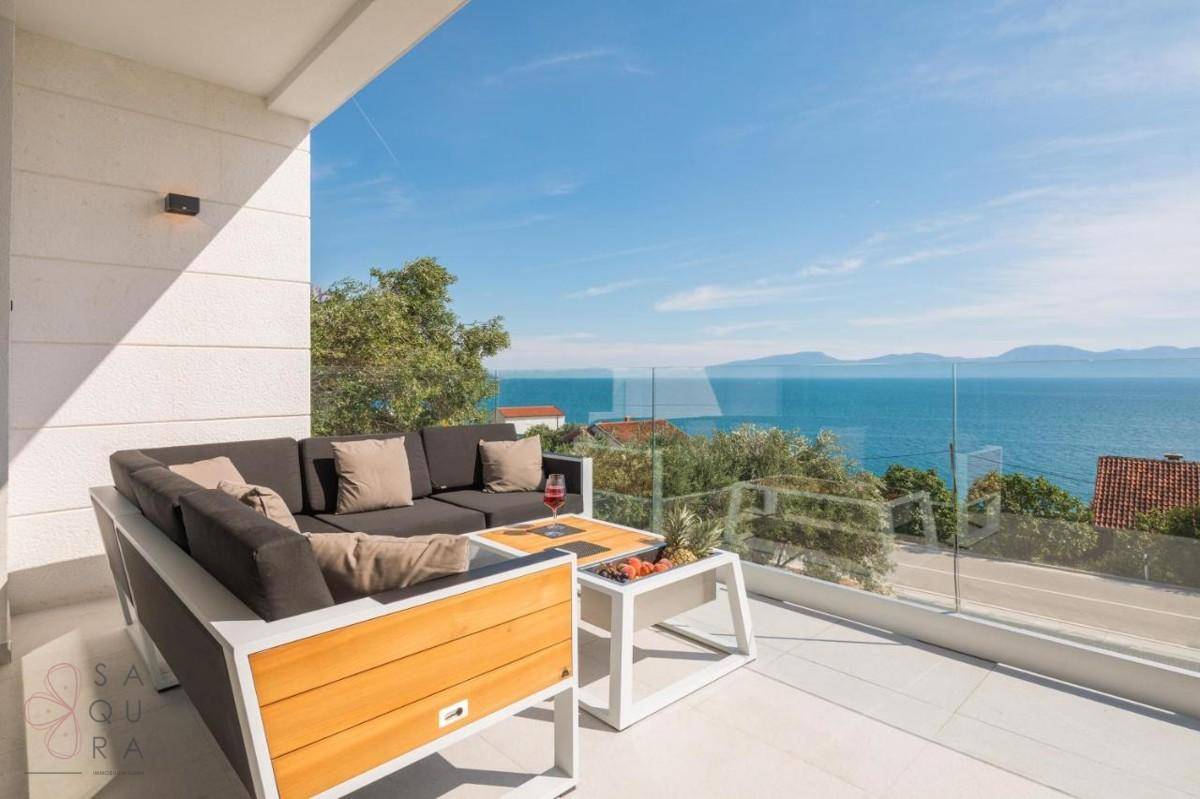 Großer Balkon mit modernen Outdoor-Lounge-Möbeln und einem spektakulären Blick auf das Meer.