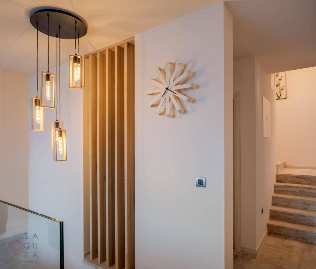 Moderner Flur mit Holzlamellenwand, stilvoller Beleuchtung und Treppenaufgang.