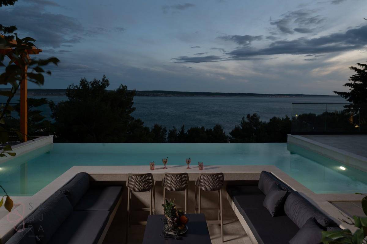 Elegante Lounge-Ecke am Pool mit Meerblick, ideal für entspannte Abende.