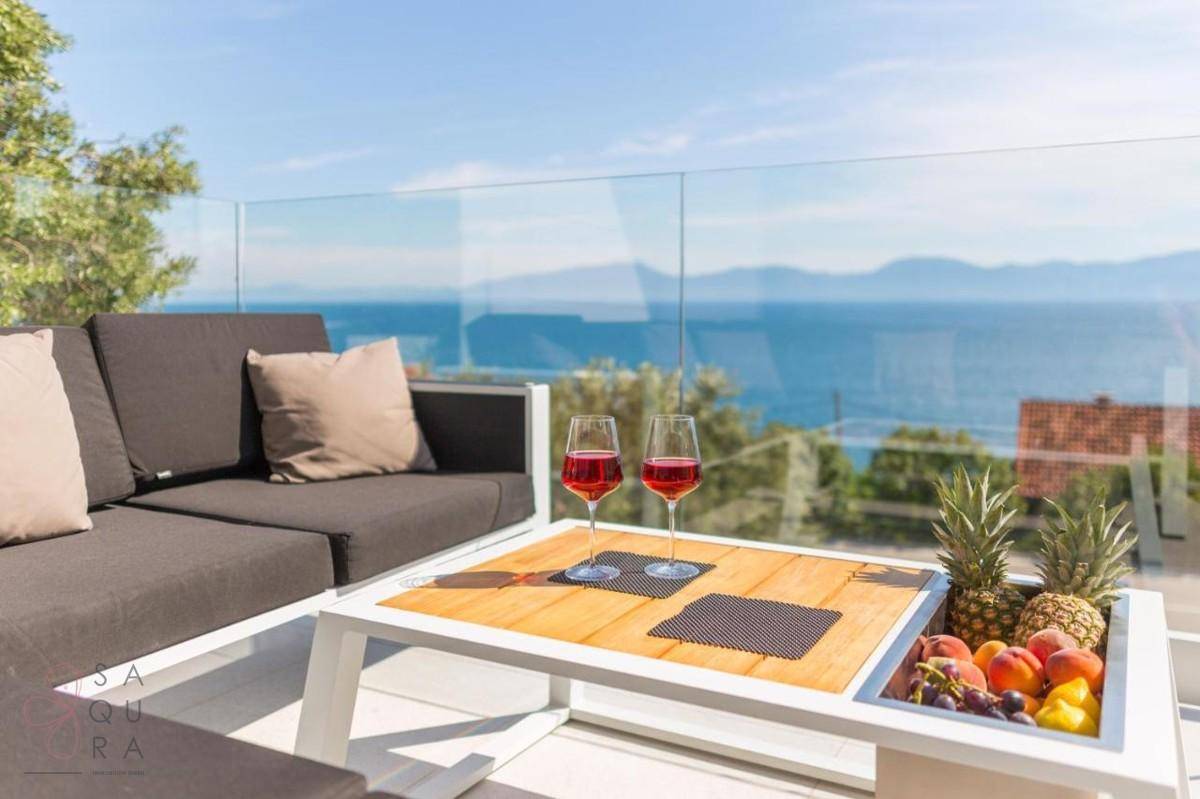 Moderne Terrasse mit bequemen Loungemöbeln, Meerblick und frischen Früchten für entspannte Stunden.