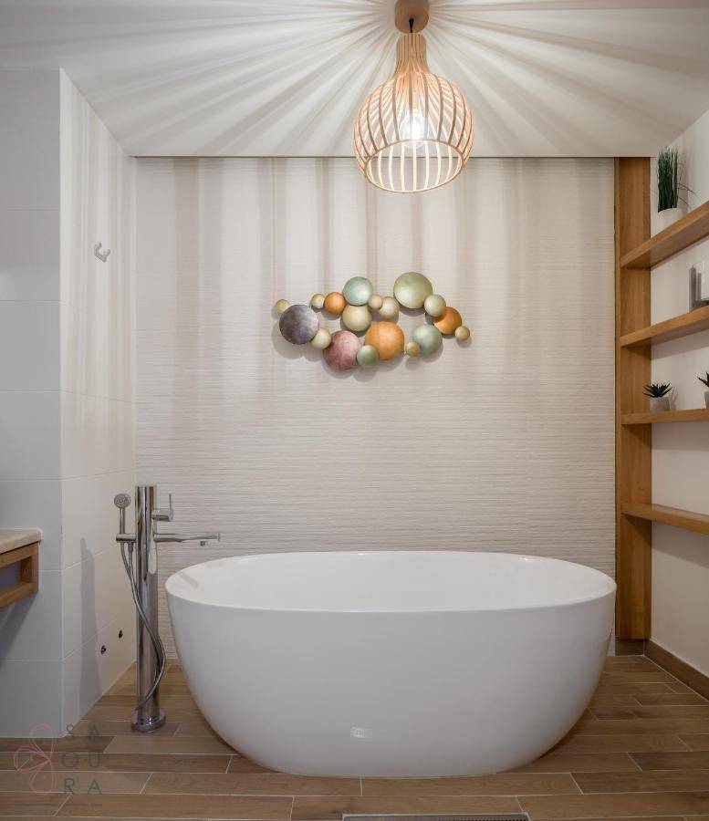 Luxuriöses Badezimmer mit freistehender Badewanne, Holzboden und dekorativer Wandkunst.