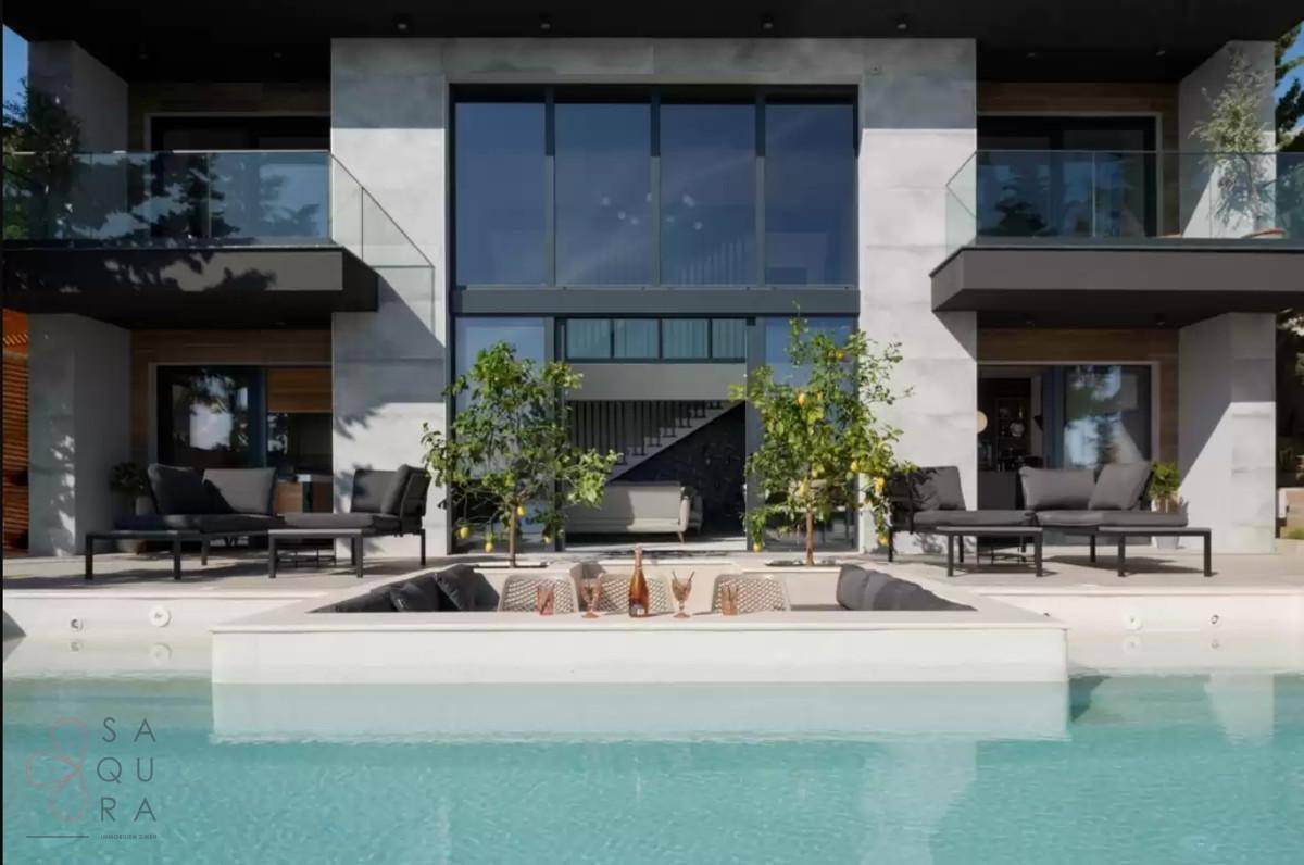 Moderne Fassade mit großen Glasfronten und direktem Zugang zum eleganten Poolbereich.