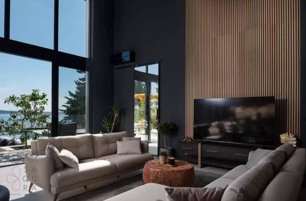 Stilvolles Wohnzimmer mit bequemen Sofas, Holzwandverkleidung und großem Fernseher.