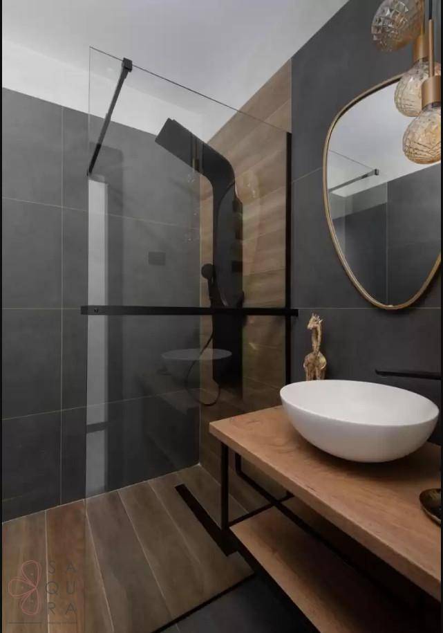 Modernes Badezimmer mit begehbarer Dusche, Holzwaschtisch, grauen Fliesen und dekorativer Beleuchtung.