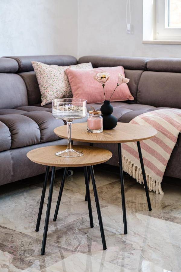 Detailaufnahme von Beistelltischen mit Dekoration und einem gemütlichen Sofa im Wohnzimmer.