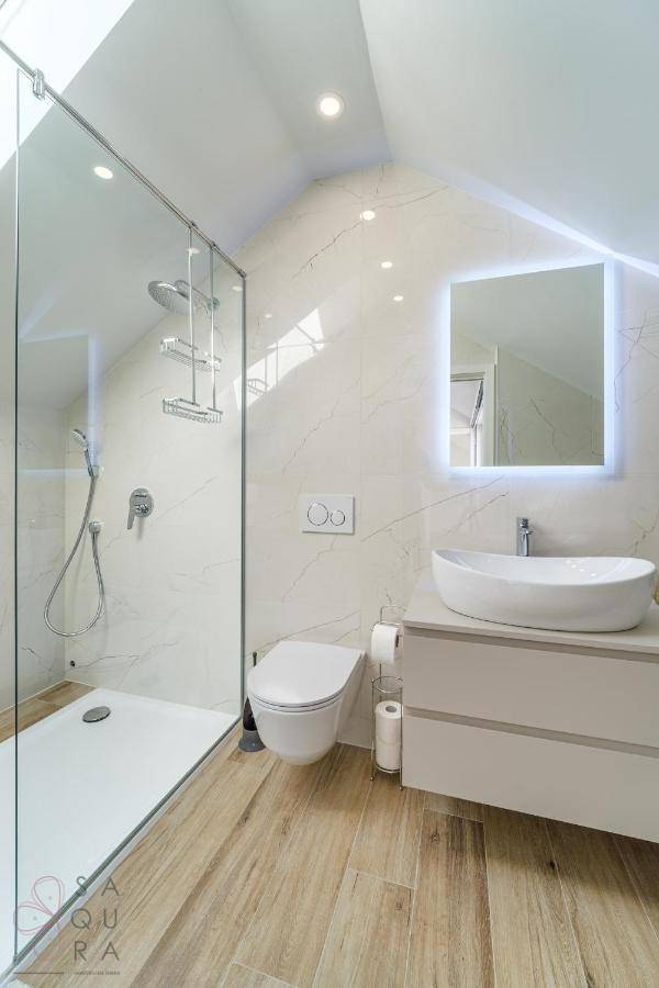 Modernes Badezimmer mit begehbarer Dusche, schwebendem Waschtisch und Marmoroptik-Fliesen.