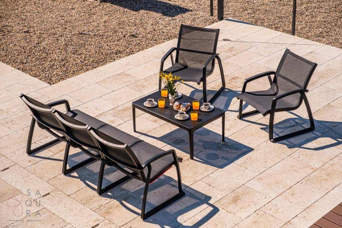 Gemütlicher Außenbereich mit modernen Gartenmöbeln und einem Tisch mit Erfrischungen.