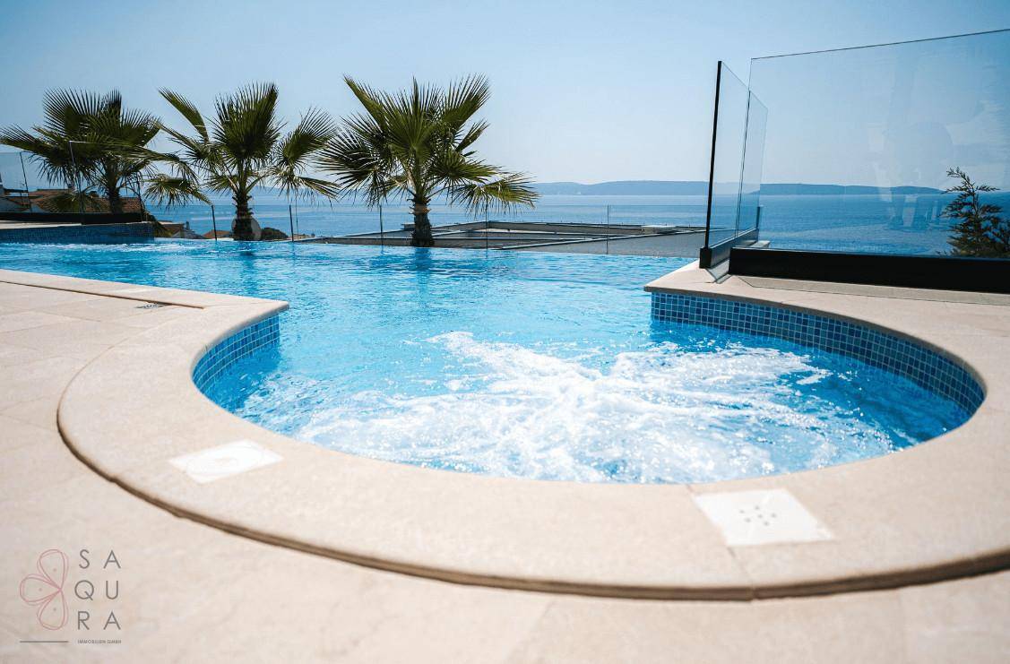 Integrierter Whirlpool im Poolbereich mit Blick auf das Meer und Palmen.
