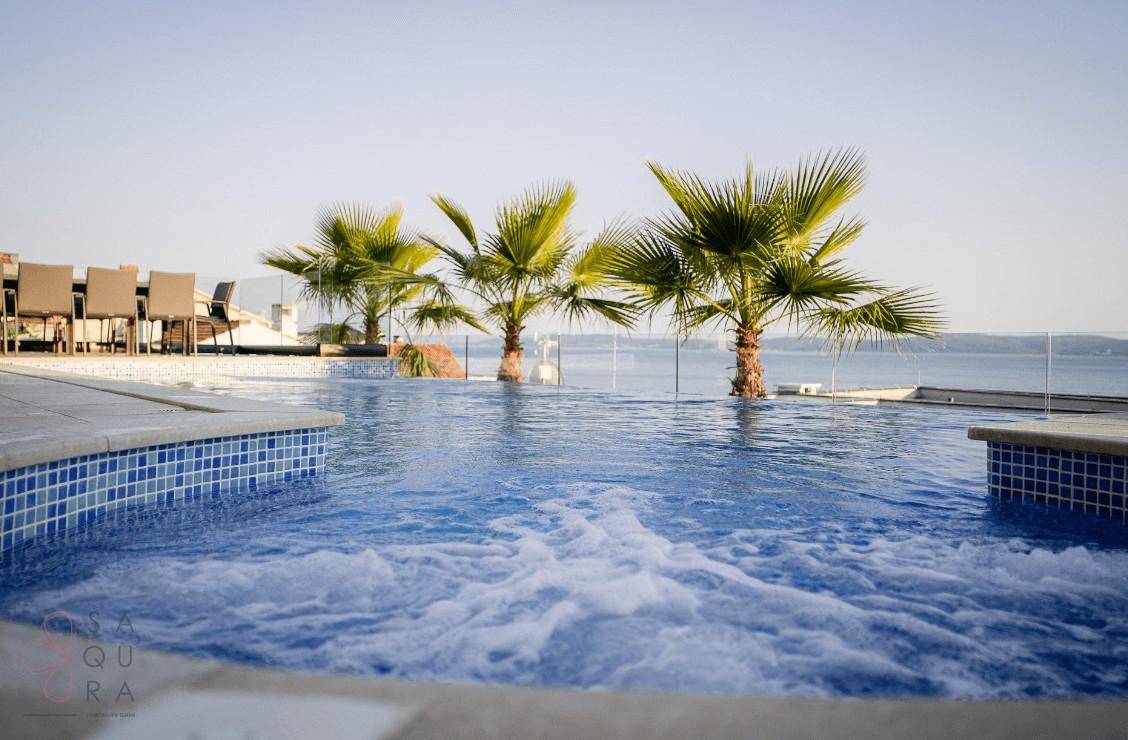 Sprudelnder Whirlpool am Infinity-Pool mit weitem Blick auf das glitzernde Meer.