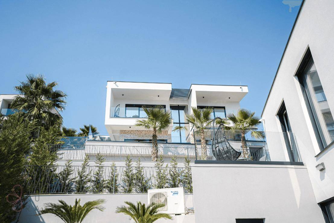 Ansicht der modernen Architektur mit weißen Fassaden und Glasbalkonen unter blauem Himmel.