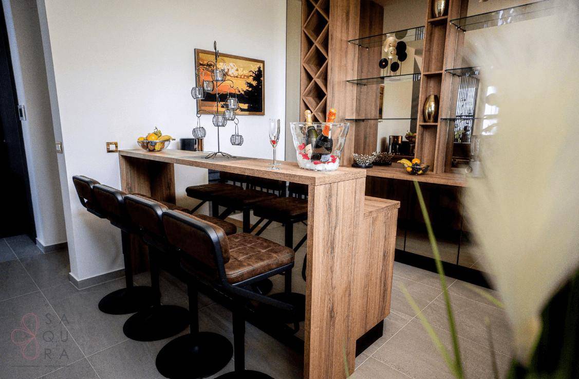 Elegante Bar mit Holztheke, Barhockern und integrierten Weinregalen.