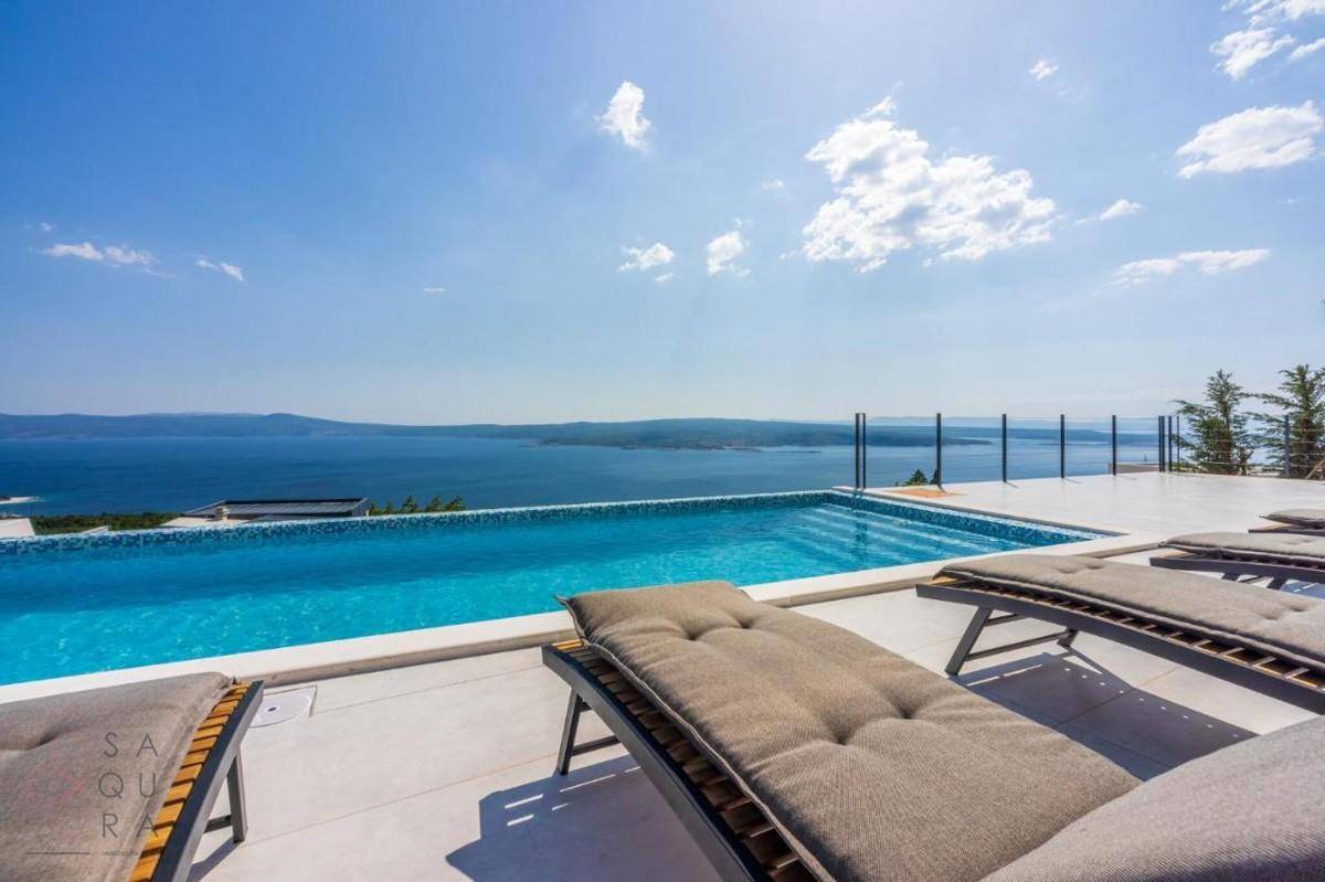 Infinity-Pool mit atemberaubendem Meerblick und bequemen Sonnenliegen auf der Terrasse.