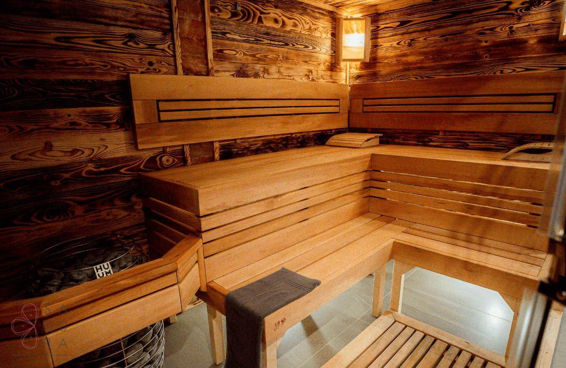 Gemütliche Sauna mit Holzbänken und traditionellem Saunaofen für Entspannung.