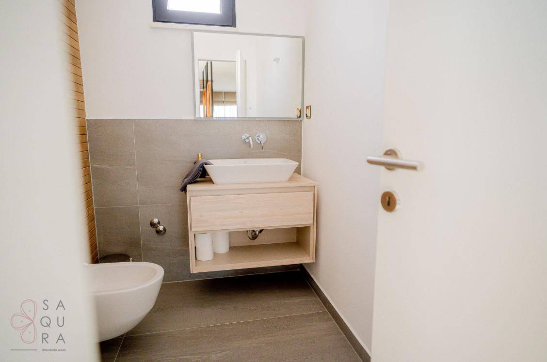 Kleines Badezimmer oder Gäste-WC mit modernem Waschbecken und Spiegel.