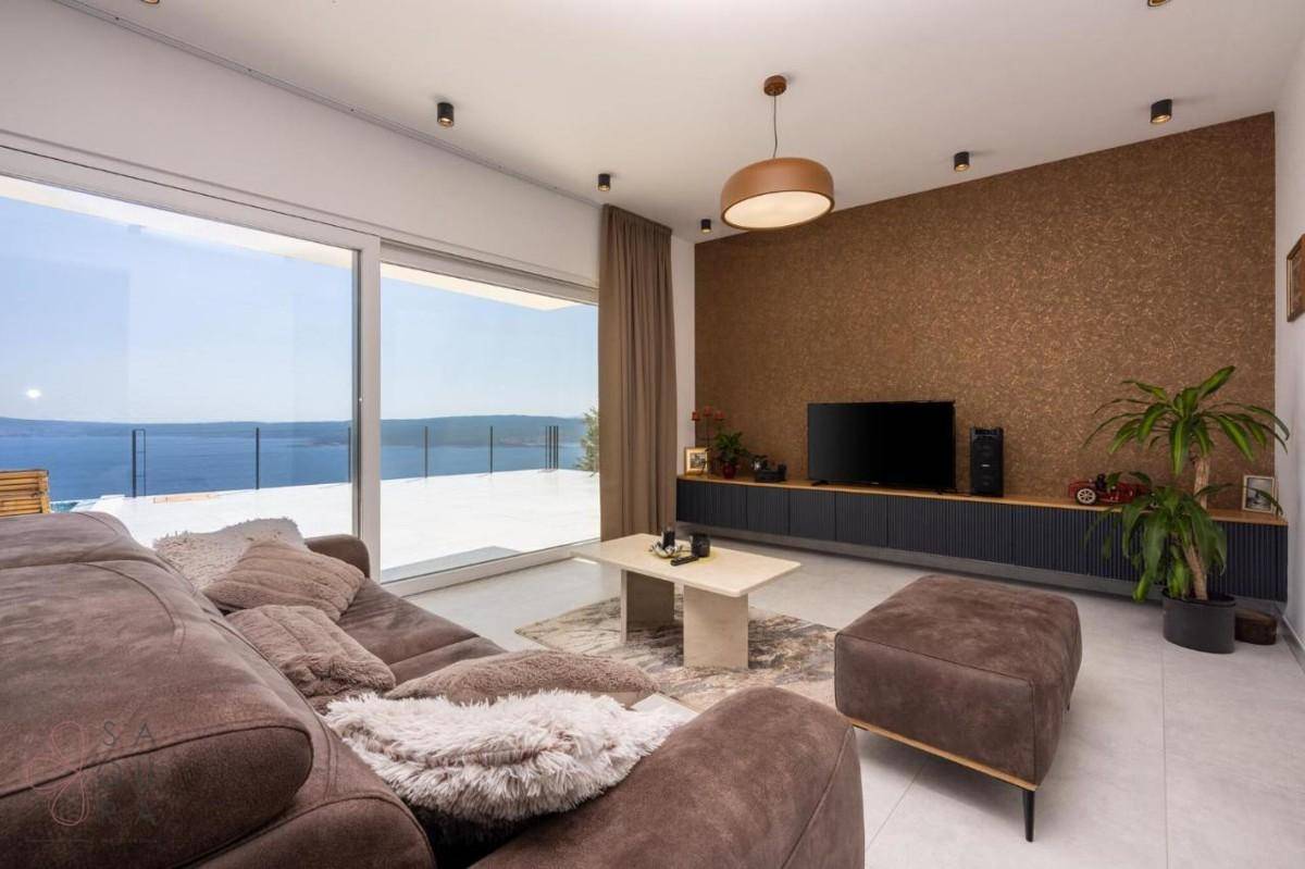 Helles Wohnzimmer mit Meerblick, bequemer Couch und stilvoller Wandgestaltung.
