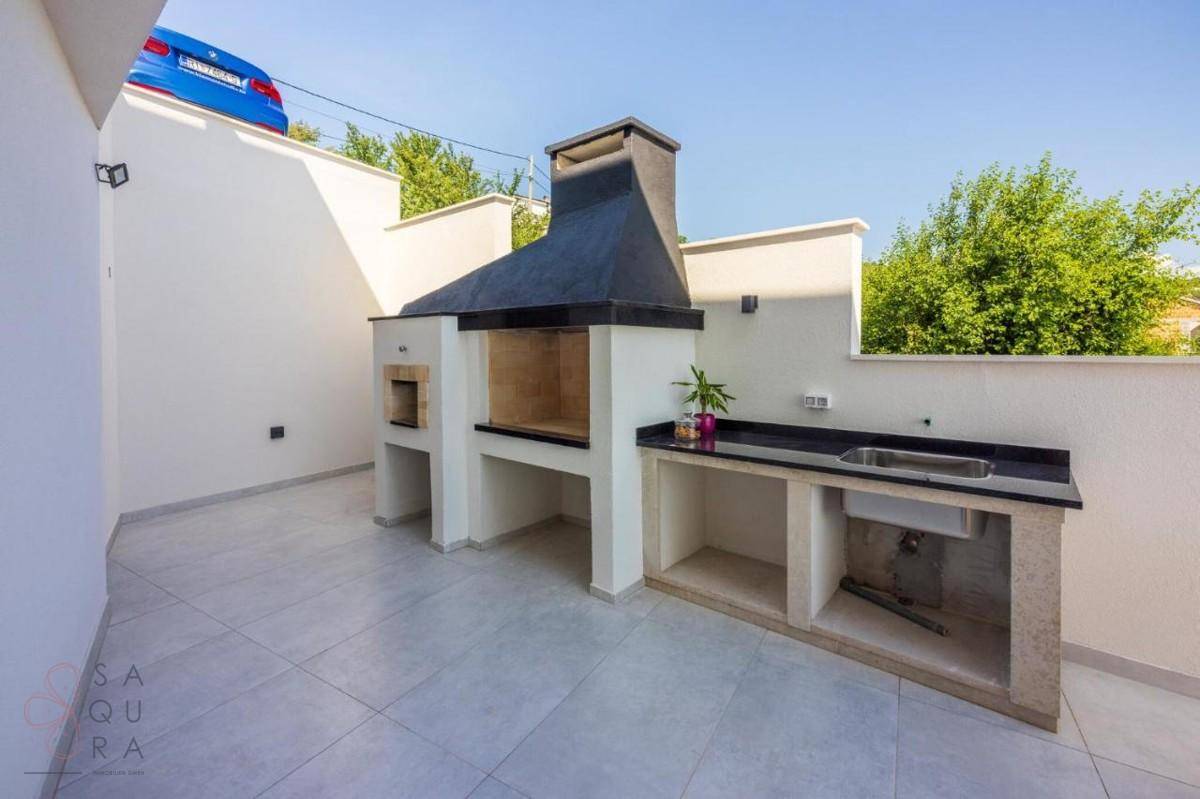 Gut ausgestatteter Grillbereich im Freien mit Spüle und Arbeitsfläche, ideal für Sommerabende.