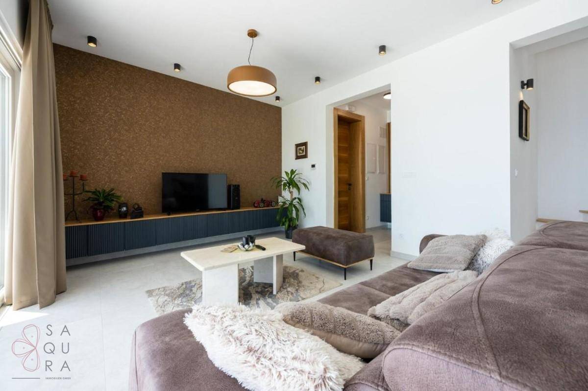 Modernes Wohnzimmer mit bequemer Couch, Fernseher und stilvoller Wandgestaltung.