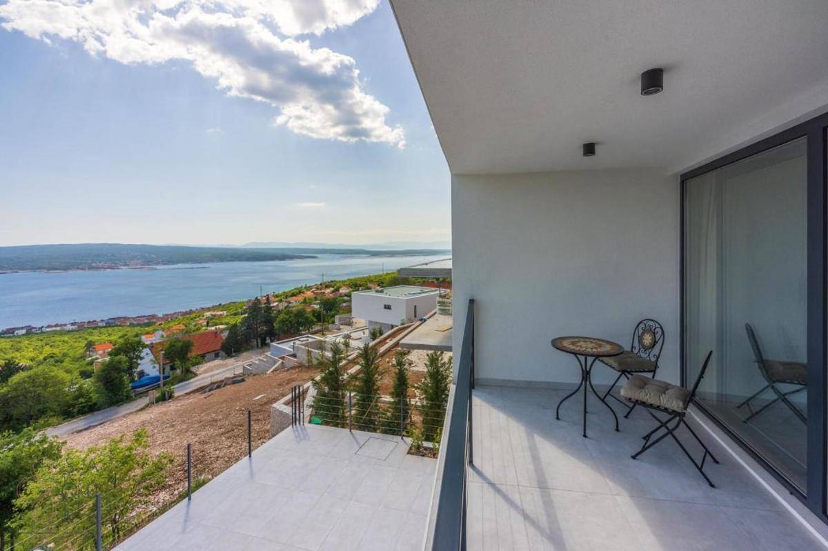 Geräumiger Balkon mit Sitzgelegenheiten und einem weiten Panoramablick über das Meer und die Küste.